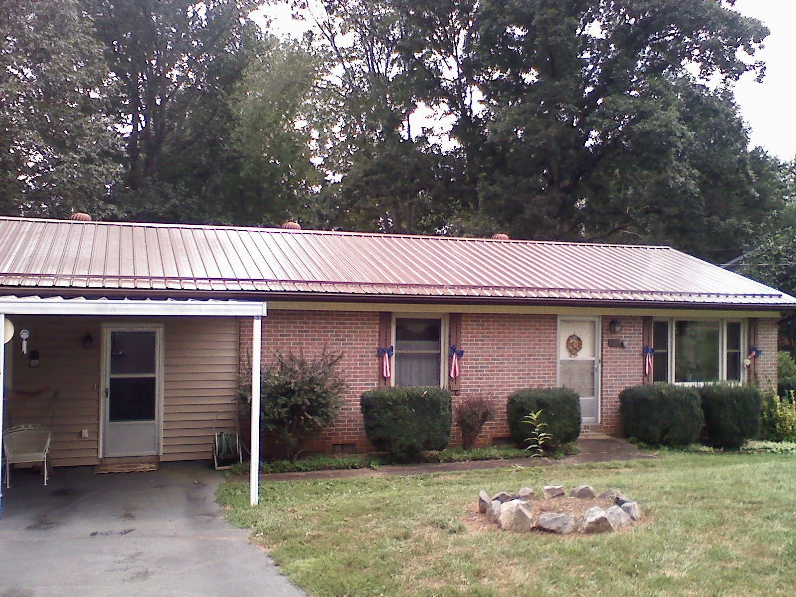 Bronze metal roof and carport on a brick ranch home — Roof Repair work by our crew in Goode